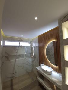 een badkamer met een wastafel en een spiegel bij Casa strella in Praia