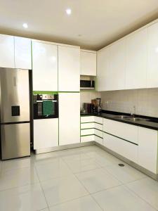 een grote keuken met witte kasten en apparatuur bij Casa strella in Praia