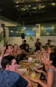 a group of people sitting at a table at Ocean Breeze Hostel by Daily Sweet in Moalboal