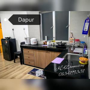 a kitchen with a black counter top and a sink at KAZ homestay in Tanah Rata
