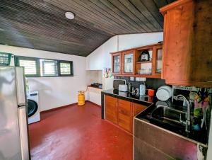 a kitchen with wooden cabinets and black counter tops at Canopy villas in Mirissa