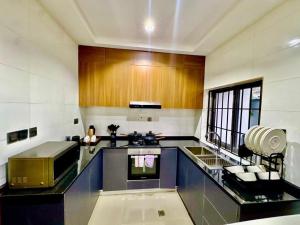 Una cocina con gabinetes de madera y encimera. en 1260 Lumaana Residence, en Garki