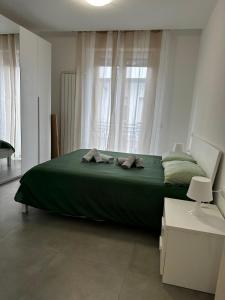 a bedroom with a large green bed in front of a window at Il Colle in Azzano Mella