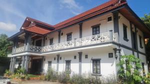 a large white building with a red roof at The ziong's inn guesthouse in Luang Prabang