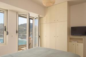 a bedroom with a bed and a tv and a window at Nere Suites in Lygaria