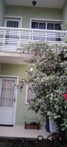 a house with a tree in front of it at Natureza e conforto na Praia da Brisa in Pedra de Guaratiba