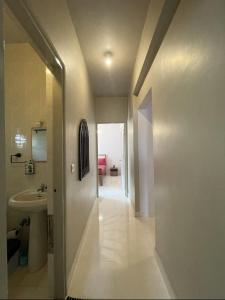 a hallway of a bathroom with a sink and a toilet at Modern 2BHK Hideout in Benaulim in Benaulim