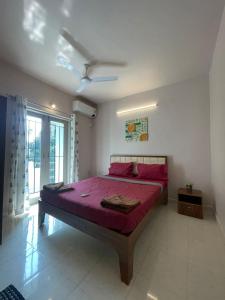 a bedroom with a large bed with red sheets at Modern 2BHK Hideout in Benaulim in Benaulim +7 photos