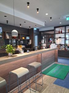 een lobby met een bar met 2 krukken bij Campanile Frankfurt Offenbach in Offenbach