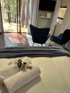a bed with a pillow and chairs in a room at Luxury Tranquil Treehouse & Hot Tub in Pretoria +52 photos