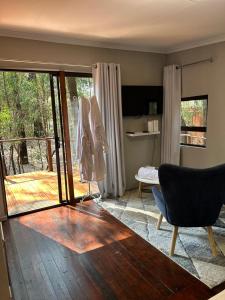 a living room with a wooden table and a sliding glass door at Luxury Tranquil Treehouse & Hot Tub in Pretoria