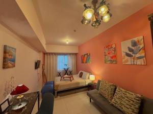 Un dormitorio con una cama y un sofá en una habitación. en Brenthill Premium Condo Baguio City with Generator, en Baguio