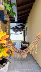 a hammock in the middle of a room with a table at Quarto na praia da Pinheira in Palhoça