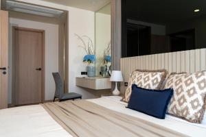a bedroom with a bed with a chair and a mirror at Bangtao Golf View Apartments in Laguna Phuket