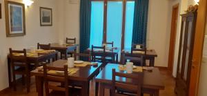 a dining room with tables and chairs and windows at B&B La Verbena in Siena