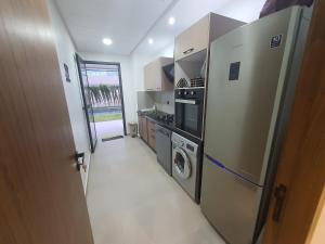 a kitchen with a refrigerator and a washer and dryer at Sancy Luxury rez de jardin avec piscine privée in Casablanca