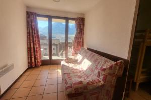 a living room with a couch and a large window at Nice studio near the ski lift in Briançon +2 photos