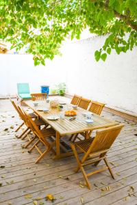 Una mesa y sillas de madera en un patio. en Villa Faraman au bord de l'eau, en Le Grau-du-Roi