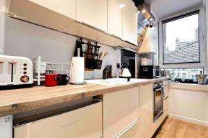 a kitchen with white cabinets and a wooden counter top at 1-Bed Apartment Sleeps 2 -Free Parking -WiFi & Tv in Dundee