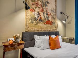 a bedroom with a bed with a painting on the wall at Timeless Prague Apartment by House of Huxe in Golčŭv Jeníkov +10 photos