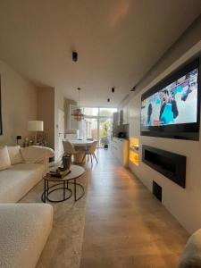 a living room with a large flat screen tv on a wall at L'Escapade in Liège