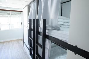 a bedroom with a bunk bed with white sheets at Hotel Nautico in Vigo