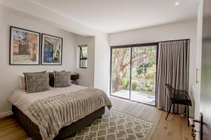 een slaapkamer met een bed en een groot raam bij Serenity on Sidwell in George