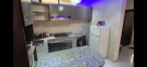 a small kitchen with a stove and a refrigerator at Thiam IMMO in Nouakchott +1 photo