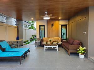 a patio with couches and chairs and a table at Chalalai Villa Private Pool Ao Nang Krabi in Ao Nam Mao
