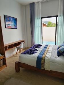 a bedroom with a bed and a large window at Chalalai Villa Private Pool Ao Nang Krabi in Ao Nam Mao