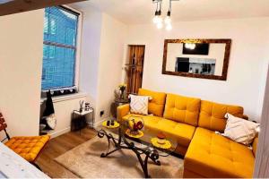 a living room with a yellow couch and a table at 1-Bed Apartment Sleeps 2 -Free Parking -WiFi & Tv in Dundee