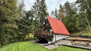 a house with a red roof and a picnic table at Chata Smrekovica in Liptovský Ján
