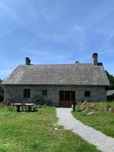 an old stone building with a picnic table in front of it at La maison des Florentins La Monédière in Chaumeil