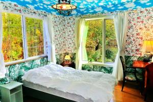 a bedroom with a bed in a room with windows at Asahikawa - house / Vacation STAY 5789 in Higashikagura