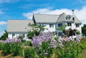 a white house with flowers in front of it at Asahikawa - house / Vacation STAY 5789 in Higashikagura