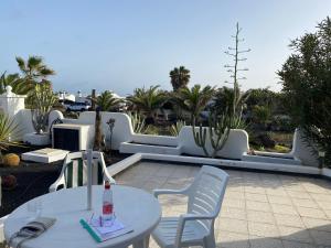 a white table and chairs on a patio at Villa Los Ojos in Charco del Palo