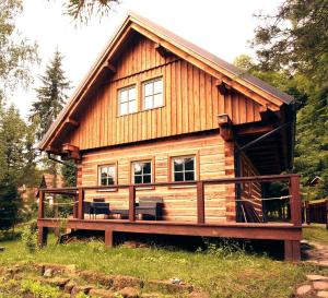 a log cabin with a deck in front of it at Roubenka Studánka in Studený +8 photos
