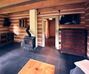 a living room with a woodburning stove and a tv at Roubenka Studánka in Studený