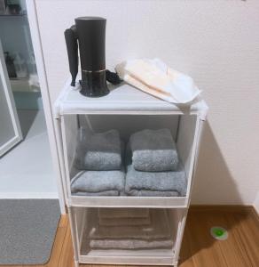 a shelf with towels and a black mug on top at コーポ川端 in Goshogawara +52 photos