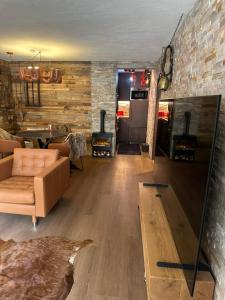 a living room with a couch and a brick wall at Zermatt Apartment in Zermatt