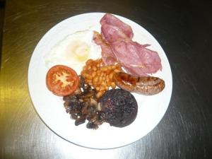a plate of food with eggs bacon beans and meat at The Georgian Guesthouse in Alnwick