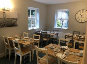 a restaurant with wooden tables and chairs and a clock at The Georgian Guesthouse in Alnwick