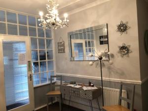 a room with a table and a chandelier at The Georgian Guesthouse in Alnwick +3 photos