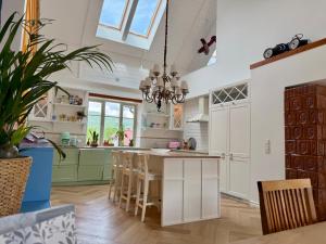 a kitchen with white cabinets and a table with chairs at Villa Pippi in Tokarnia