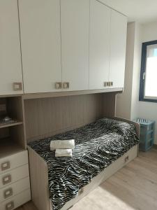 1 dormitorio con 1 cama con armarios blancos y toallas en Casa Vacanze Da Anna, en Grosio