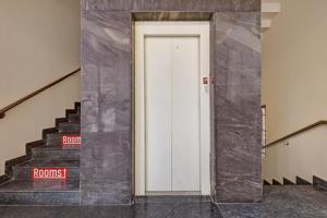 a hallway with a white door and some stairs at Hotel O Maruthi Paradise Netaji Udyanavana Park in Bengaluru