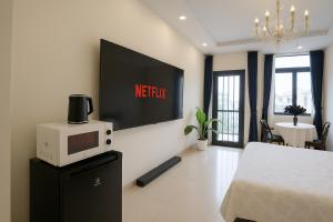 胡志明市The Writeriana de Lumière的一间带电视和微波炉的客厅