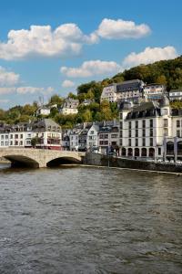 a city with a bridge over a river with buildings at Hôtel Panorama - Vue exceptionnelle sur la Semois in Bouillon