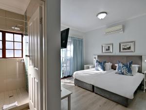 a hotel room with a bed and a bathroom at ANEW Resort Wilderness Garden Route in Wilderness