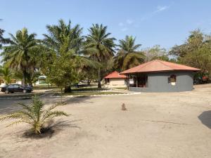 un bâtiment sur une plage avec des palmiers et une voiture dans l'établissement Wunderland River Lodge, à Kubuni